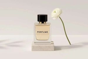 بطری عطر لوکس با درب مشکی و پس‌زمینه سفید/خاکستری روشن، قرار گرفته روی پایه سنگ مرمر و یک گل سفید ساده به عنوان عنصر تزئینی.